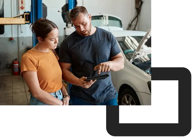 PAC-a woman talking to a mechanic in an auto repair shop
